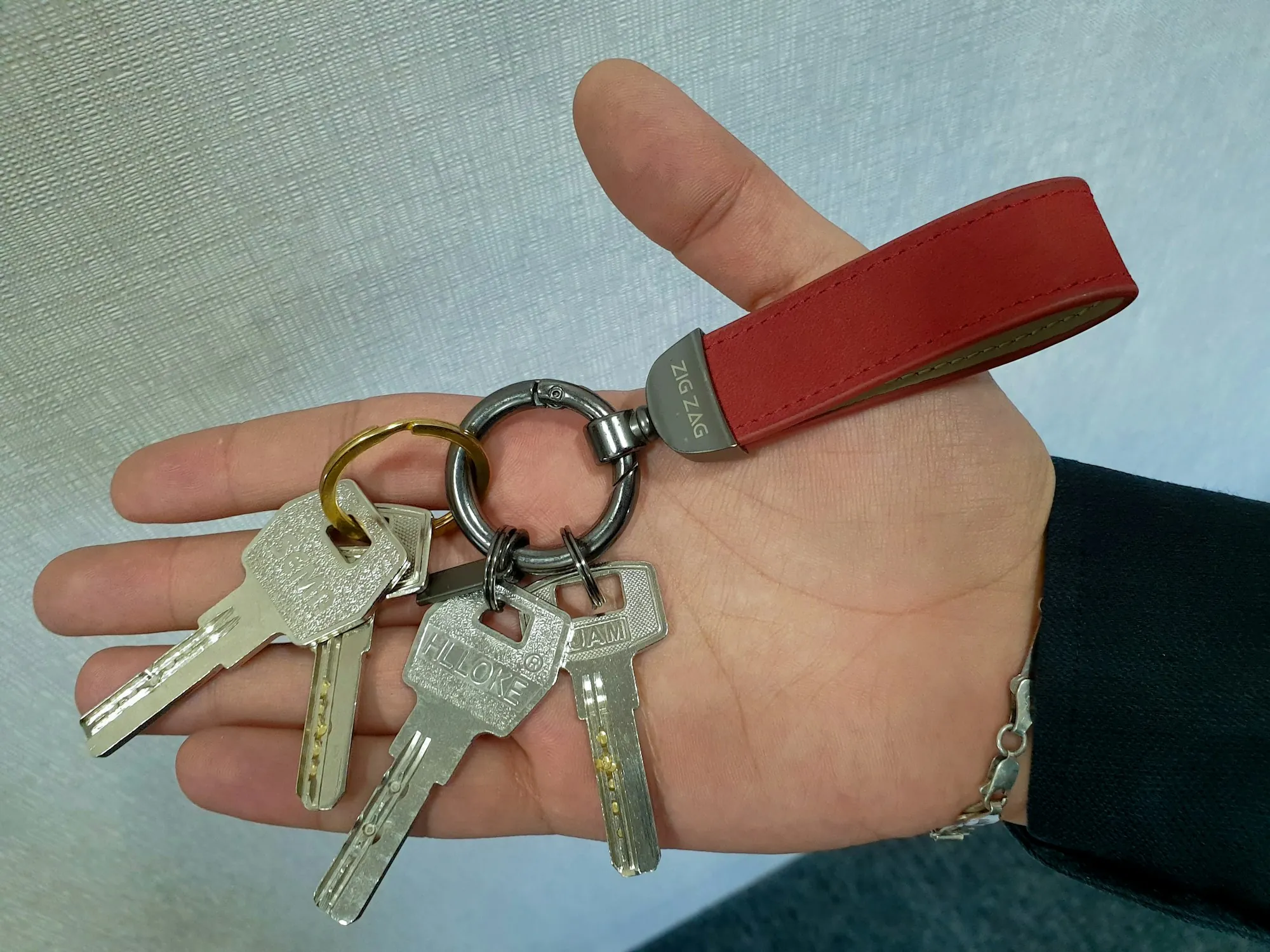 Open palm holding a ring of keys with a leather strap