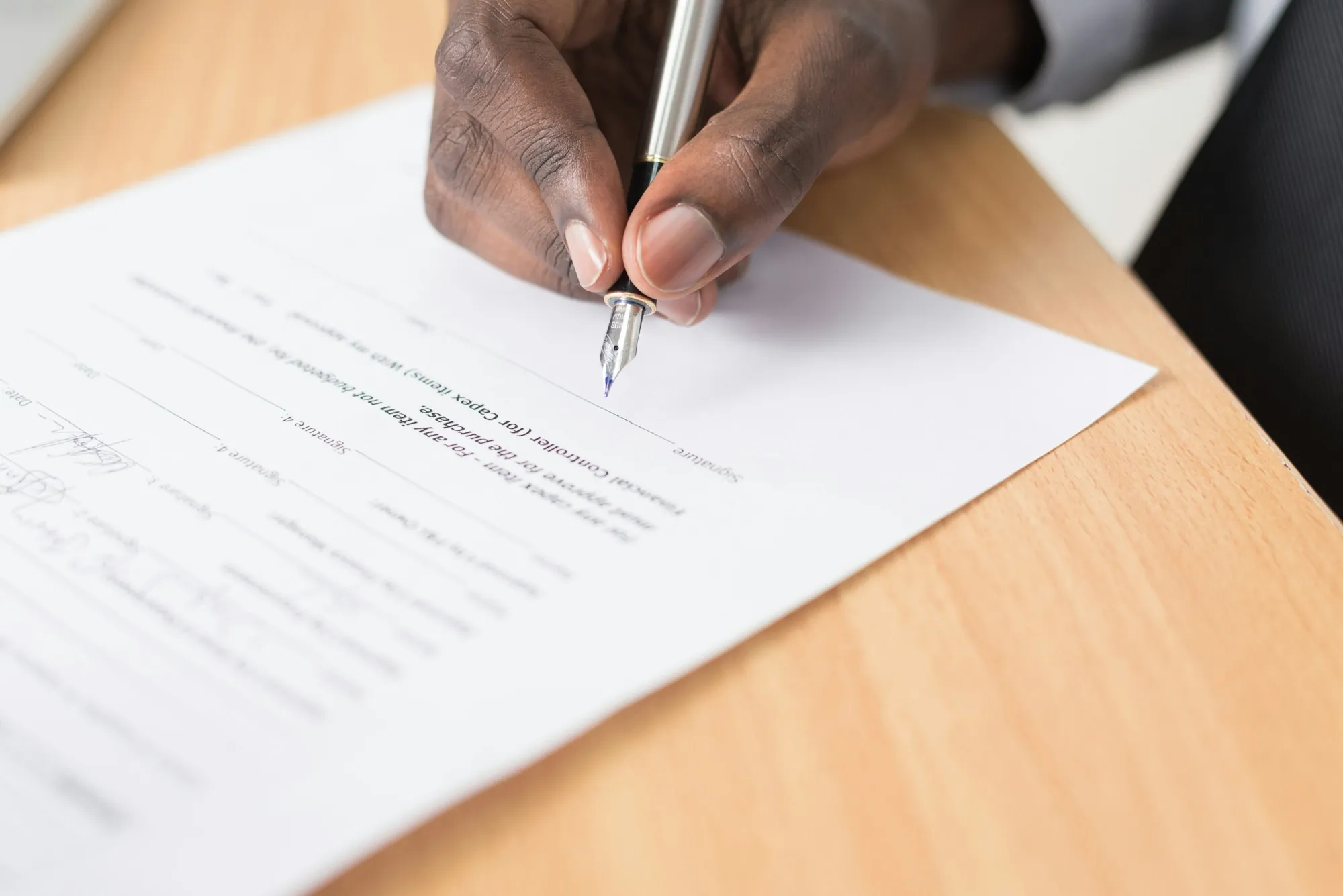 Hand signing a page with a fountain pen